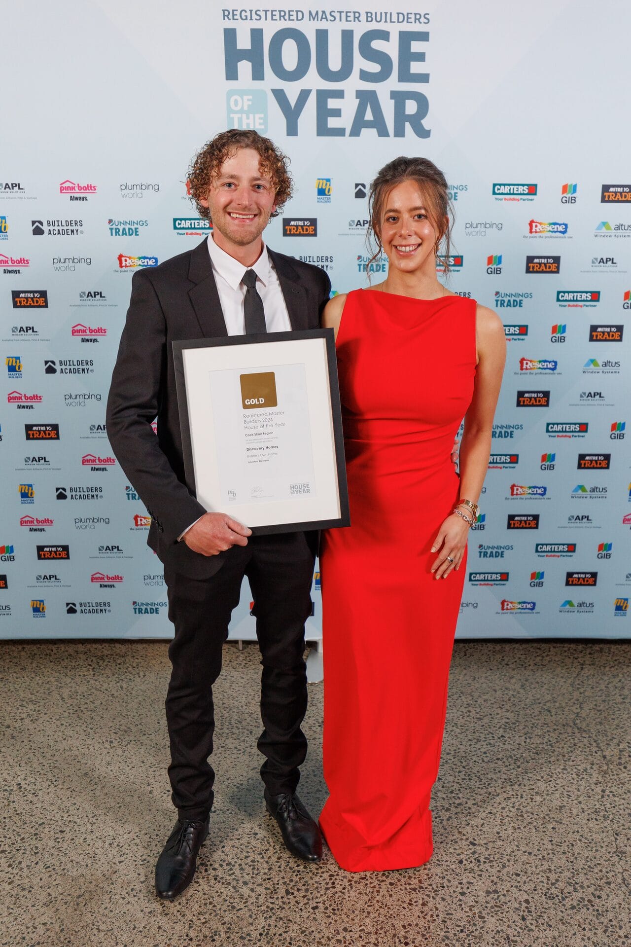 A team member with their partner holding the Discovery Homes Gold Award at House of the Year 2024