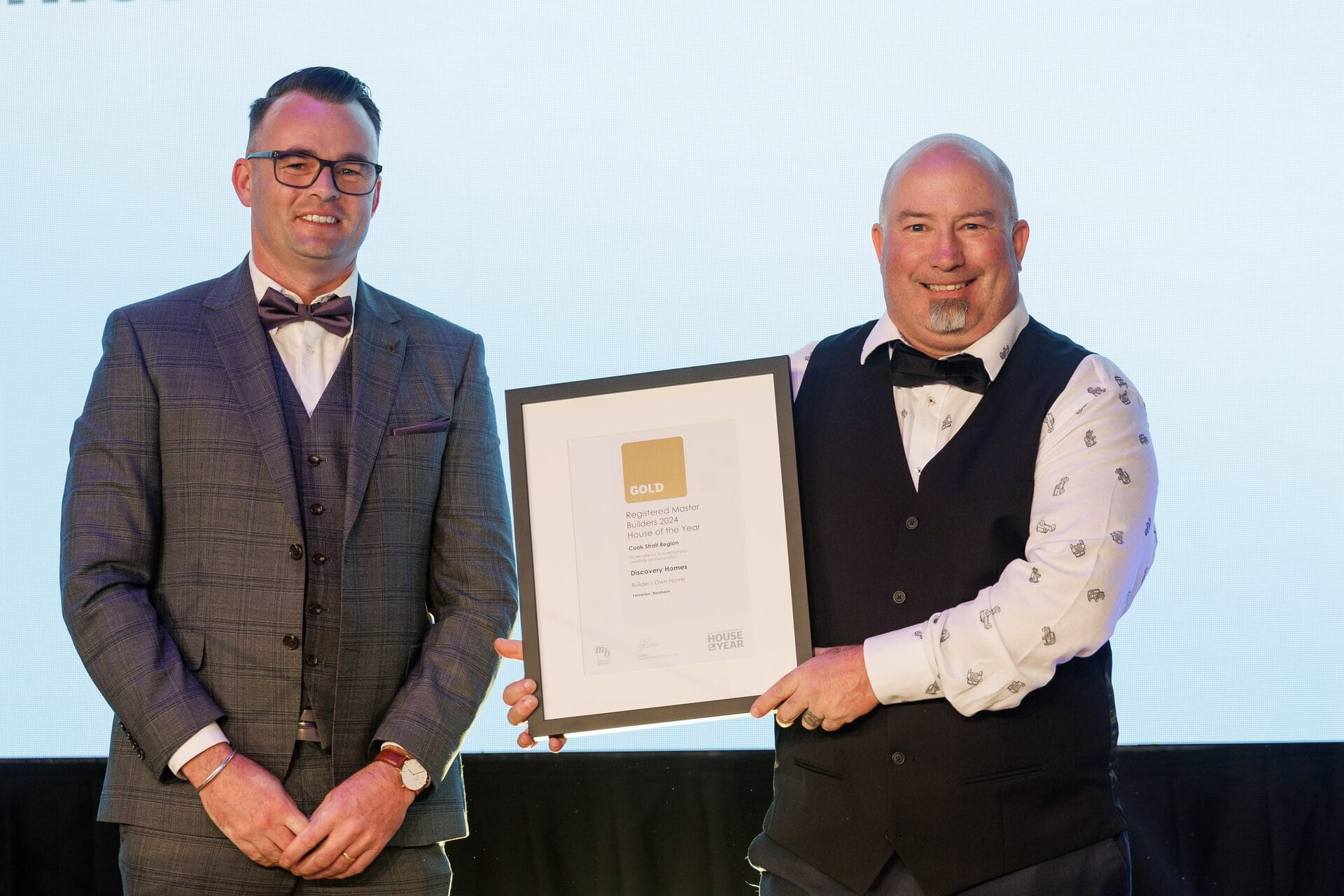 Ben Grady receiving the Gold Award certificate on stage at House of the Year 2024