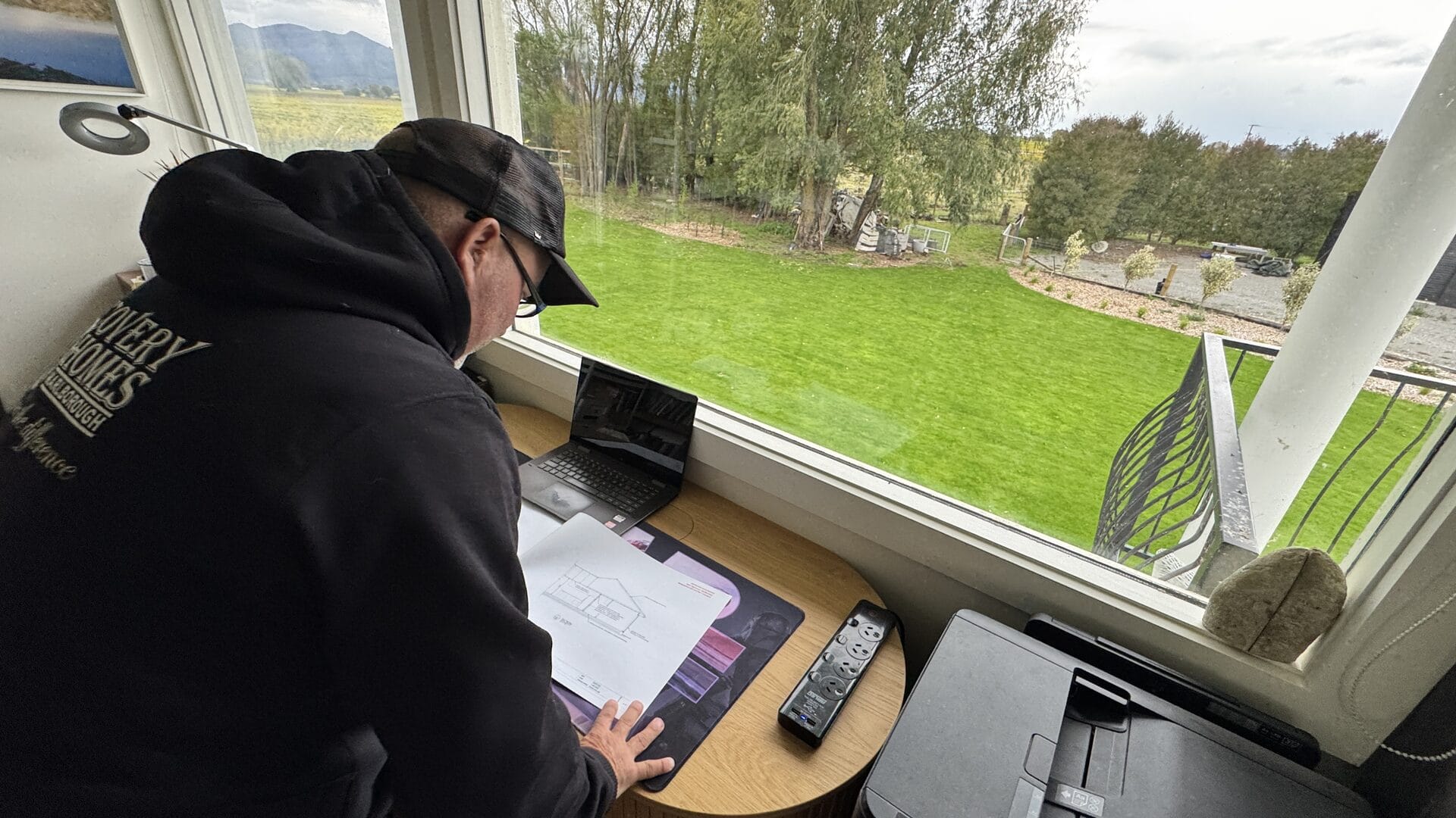 Ben Grady reviewing house plans at a Discovery Session, looking out across a Marlborough garden