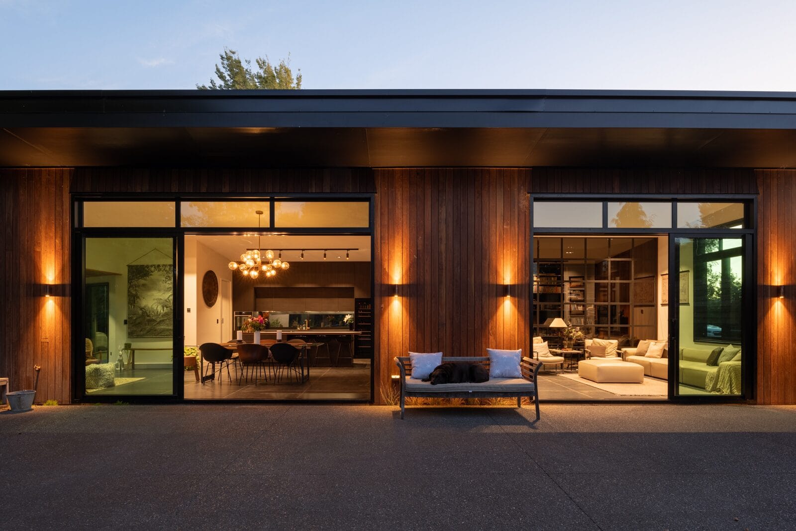 Grady Home — warmly lit evening exterior through full-height glazing