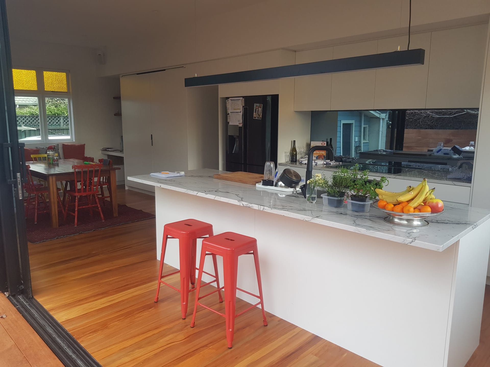 Darling renovation kitchen with marble island and red barstools