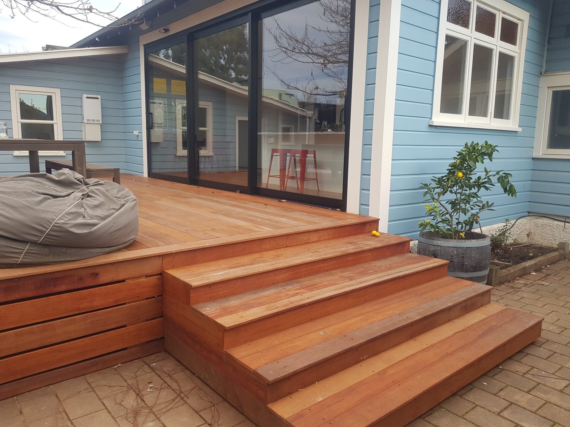 Renovated weatherboard home with new hardwood deck, steps and sliding doors opening to the outdoor living area