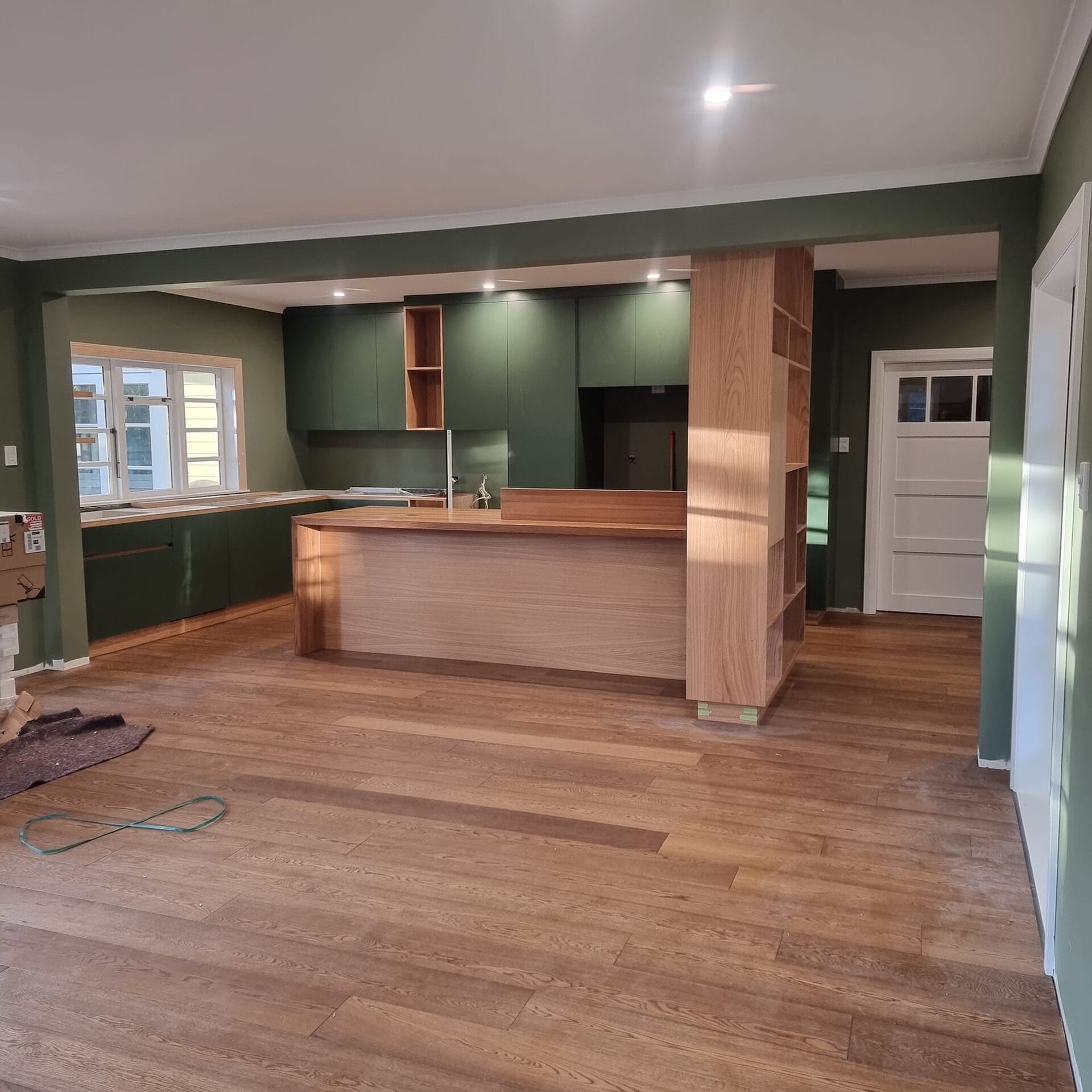 Smalls renovation kitchen with deep green joinery and oak island