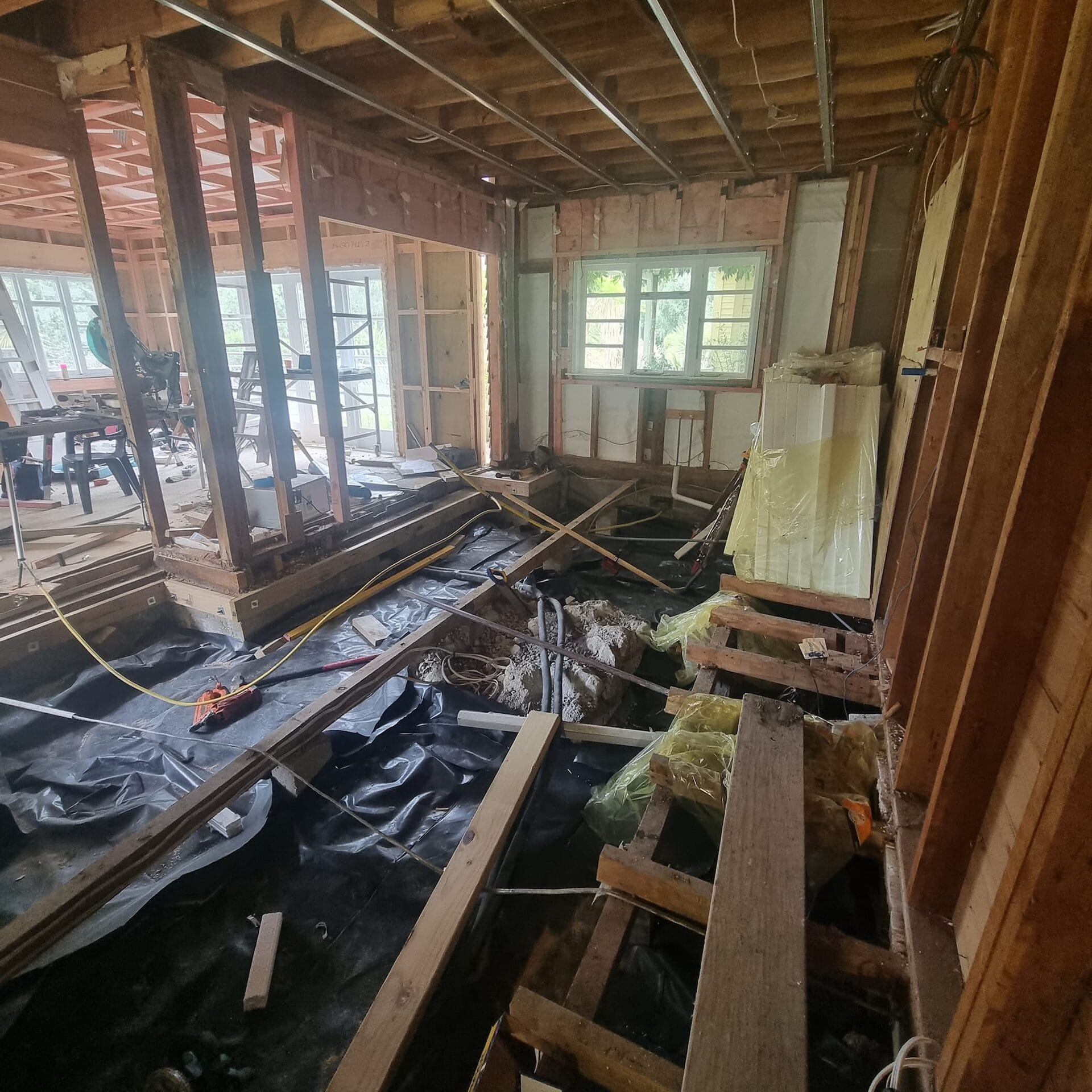 Smalls — subfloor opened up showing replaced floor joists and additional piles